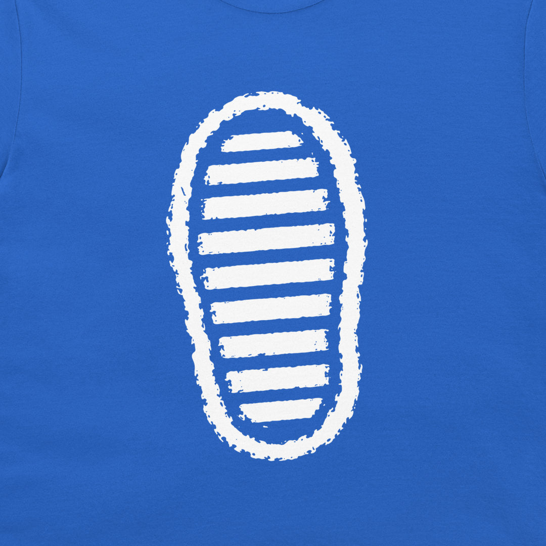 A close-up of a royal blue t-shirt, featuring a white graphic print of a shoe sole with horizontal stripes.