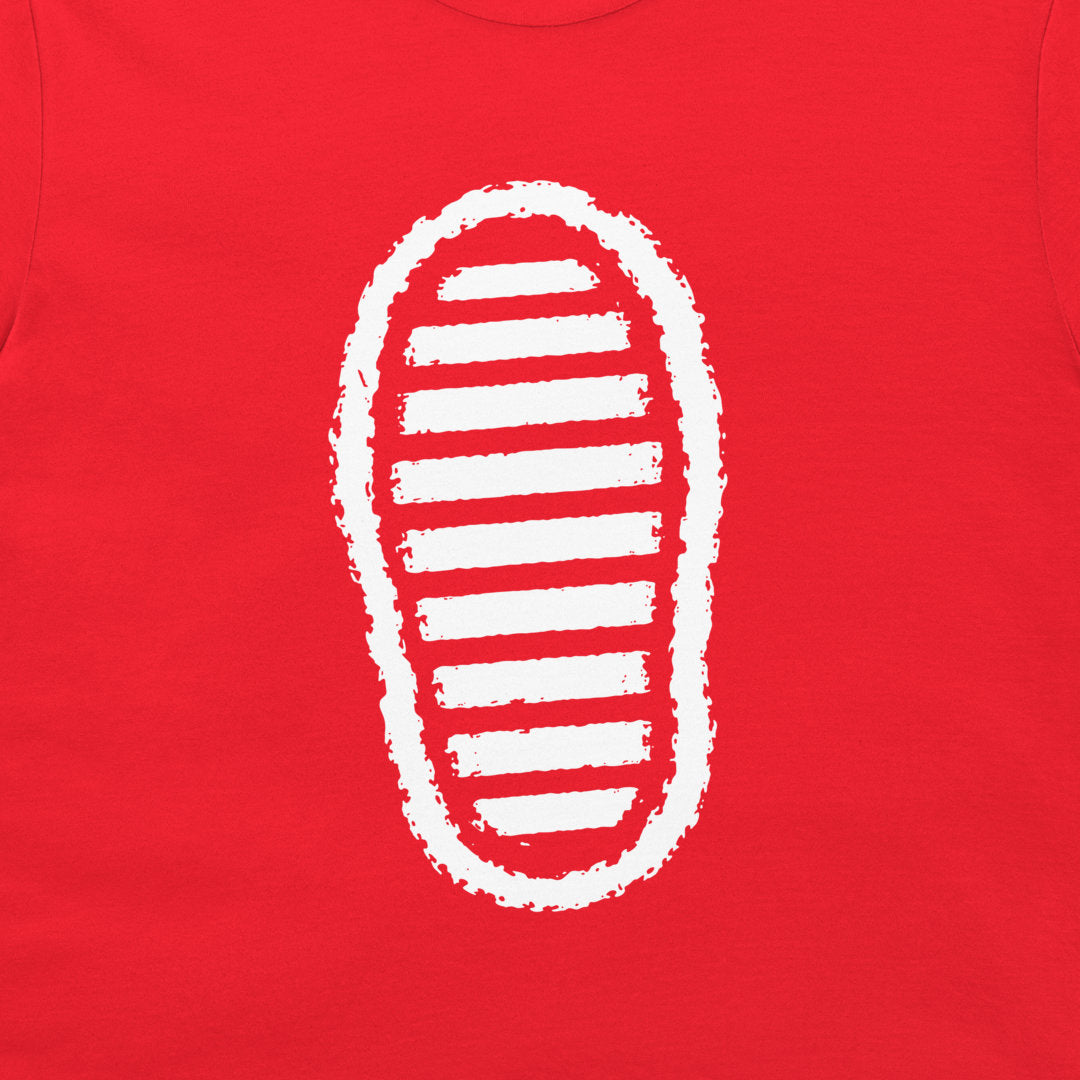 A close-up of a bright red t-shirt, featuring a white graphic print of a shoe sole with horizontal stripes.