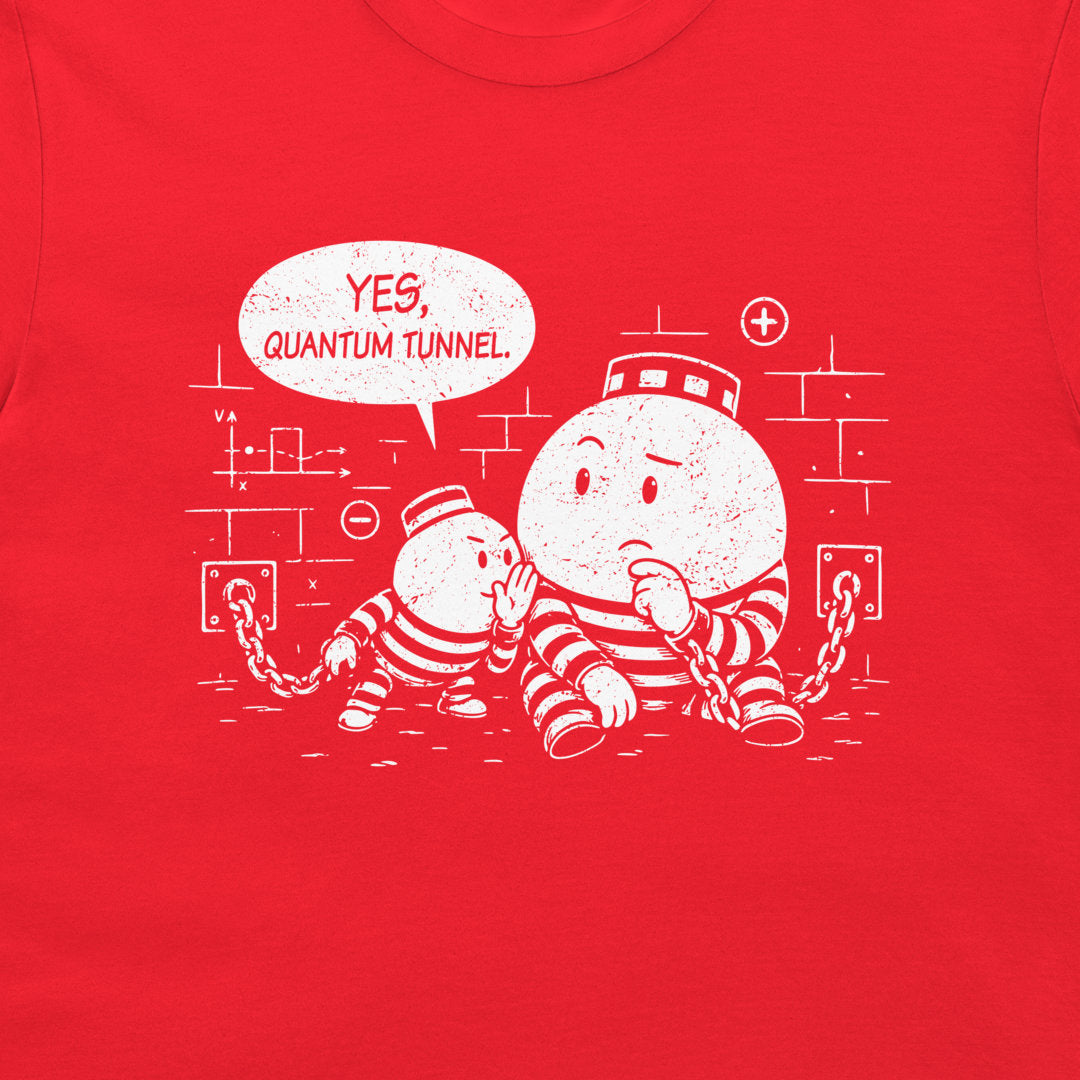 A close-up of a bright red t-shirt, featuring a white distressed graphic of two cartoon particles in striped prison uniforms with a speech bubble that reads 'YES, QUANTUM TUNNEL'.