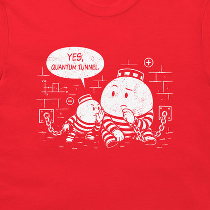 A close-up of a bright red t-shirt, featuring a white distressed graphic of two cartoon particles in striped prison uniforms with a speech bubble that reads 'YES, QUANTUM TUNNEL'.