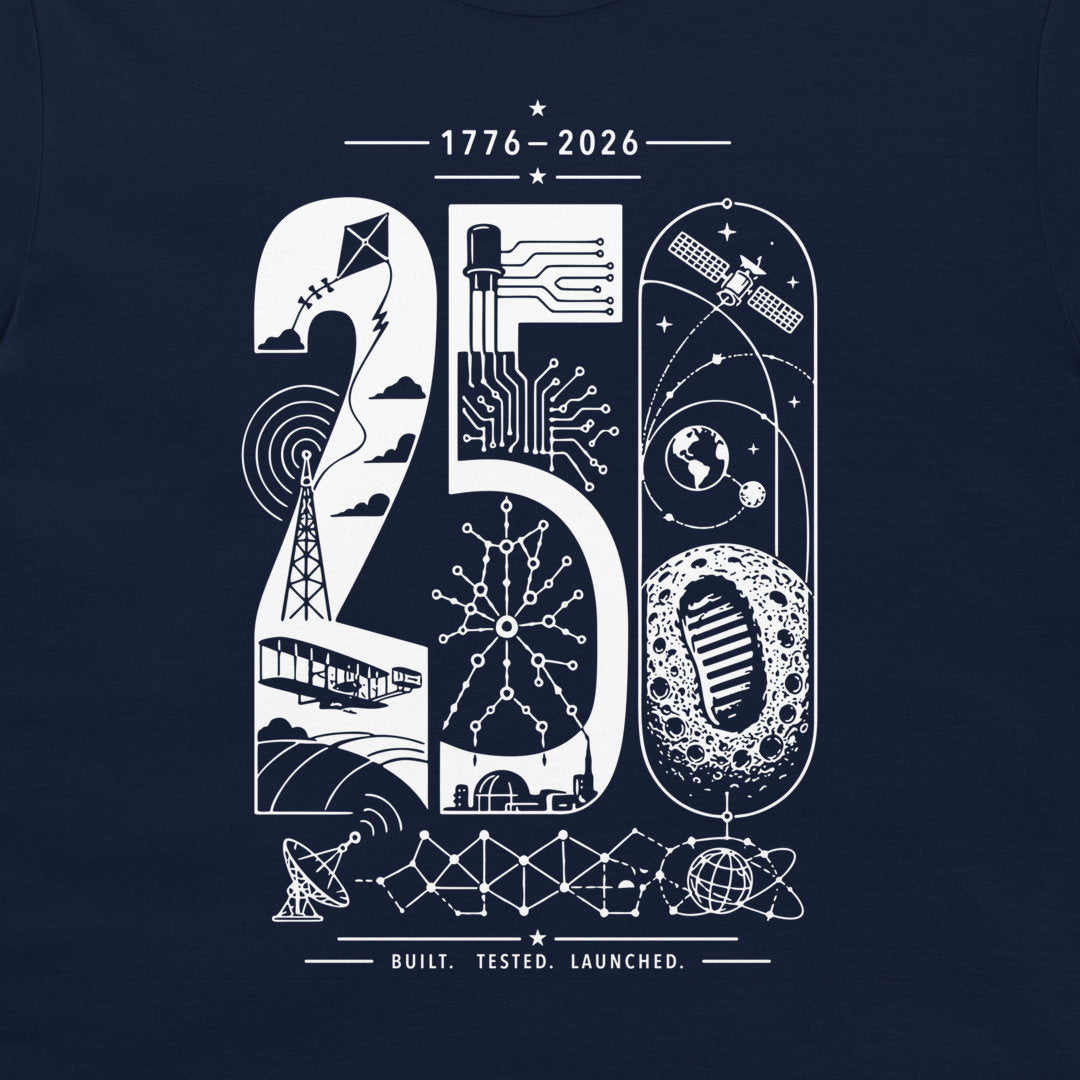 A navy blue t-shirt featuring a white graphic print of the number 250, decorated with space-themed illustrations such as a satellite, moon, rocket, and circuitry, with the text '1776-2026', 'BUILT. TESTED. LAUNCHED.'.