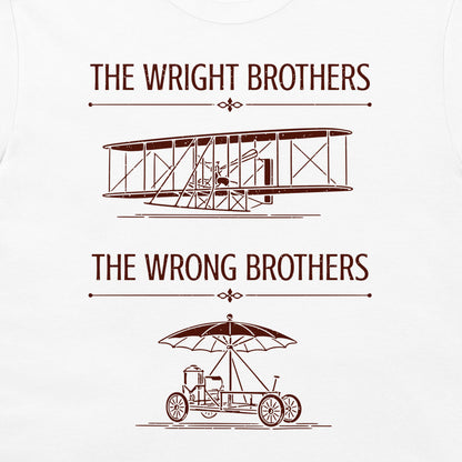 A white t-shirt featuring a red-brown graphic print with the text 'THE WRIGHT BROTHERS' above a line drawing of a vintage biplane, and 'THE WRONG BROTHERS' below a line drawing of an early automobile with an umbrella.