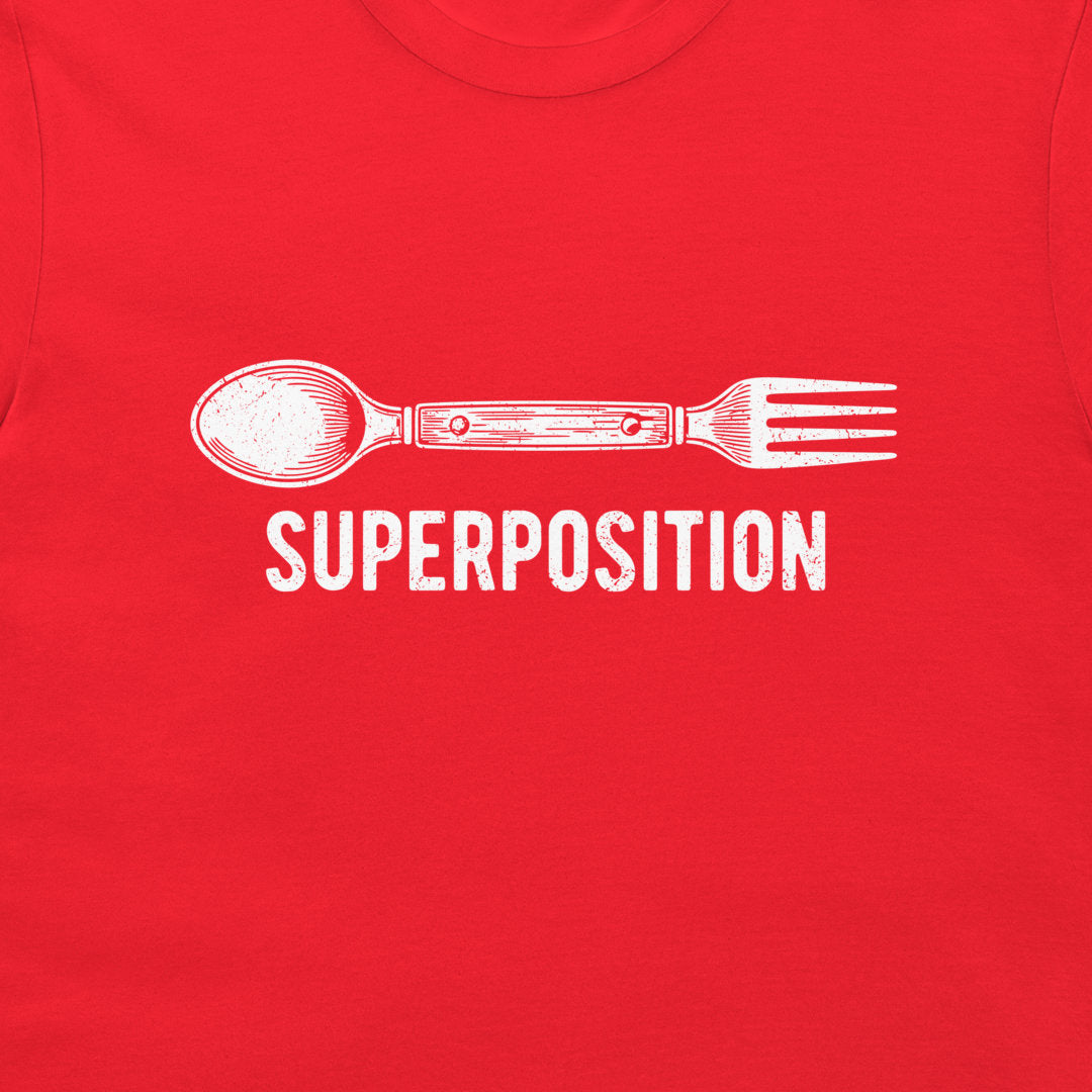 A close-up of a red t-shirt featuring a white graphic of a spoon fused with a fork, with the word 'SUPERPOSITION' printed below in a distressed white font.