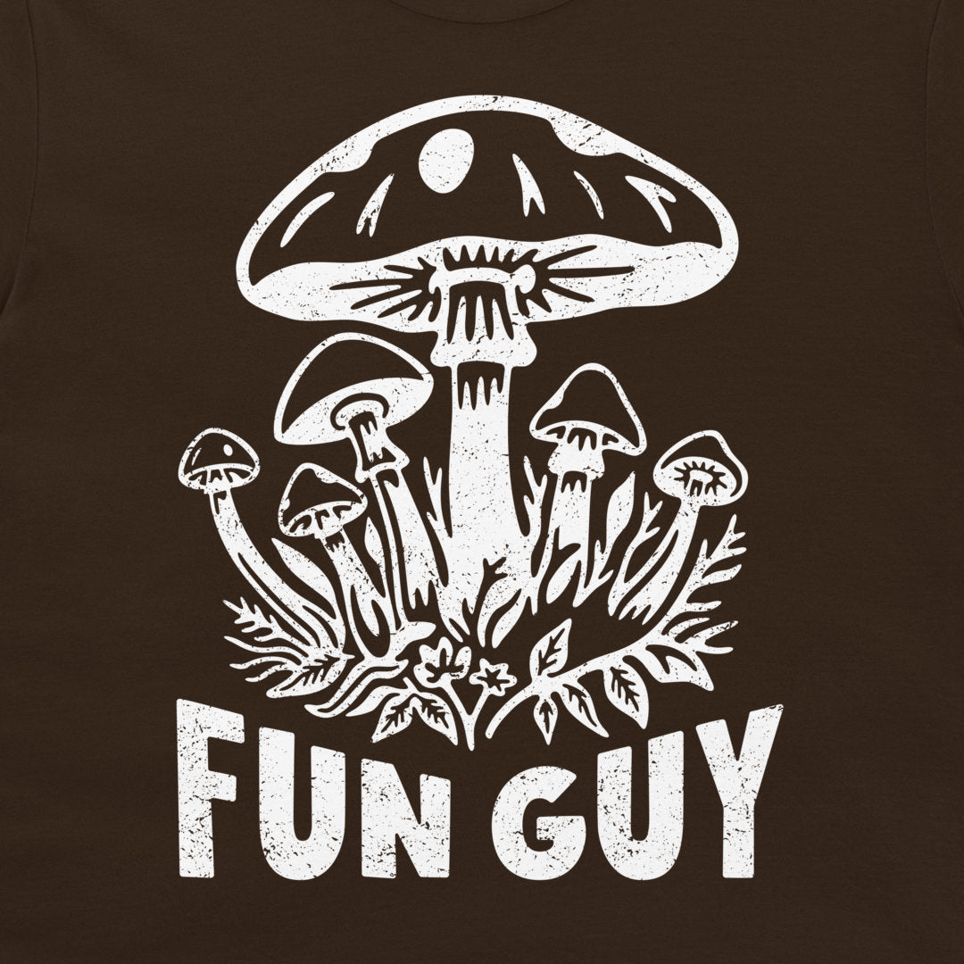 A close-up of a dark brown t-shirt, featuring a distressed white graphic of various mushrooms and the text 'FUN GUY'.