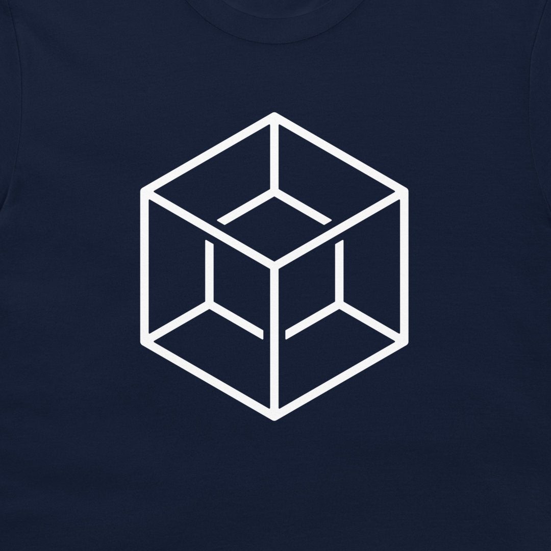 A close-up of a navy blue t-shirt featuring a white minimalist geometric cube graphic printed on the chest.