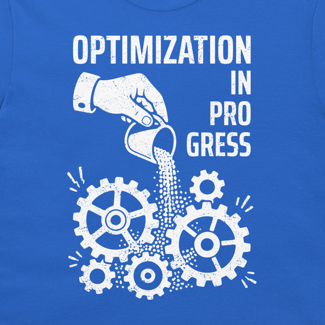 A close-up of a blue T-shirt with a white distressed graphic print that reads 'OPTIMIZATION IN PROGRESS' above a hand pouring sand into interlocking gears.