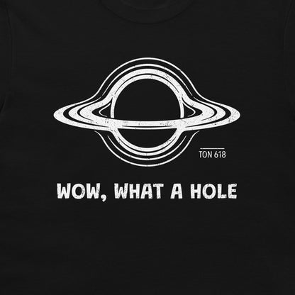 A close-up of a black t-shirt, featuring a white distressed graphic o a black hole with the text 'WOW, WHAT A HOLE' and 'TON 618' printed below it.