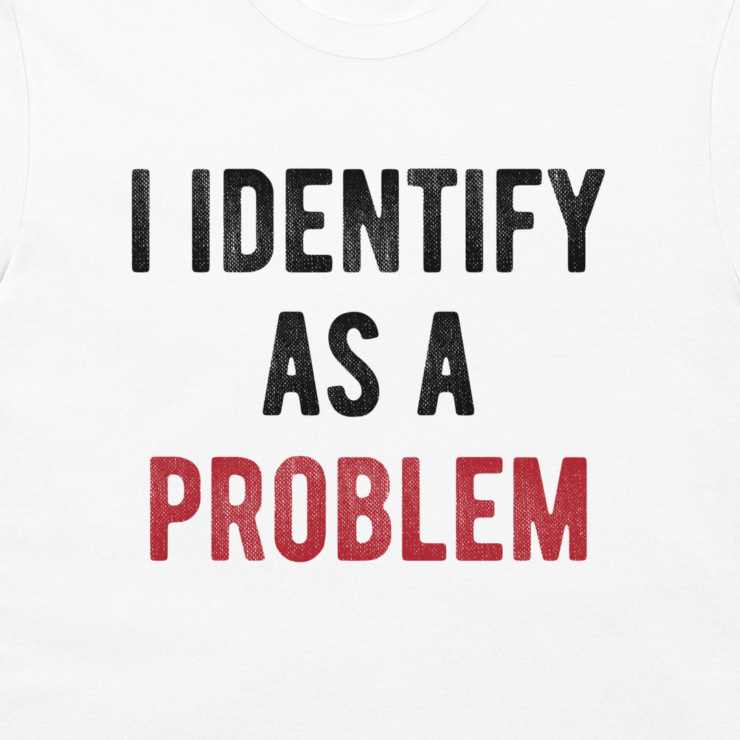 White t-shirt featuring the printed text 'I IDENTIFY AS A PROBLEM' in distressed black and red lettering.