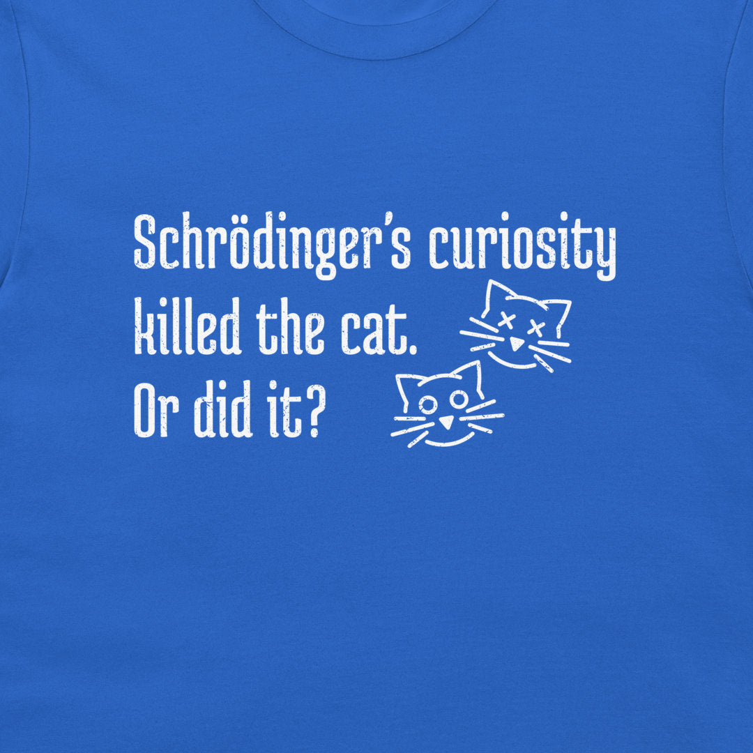 A close-up of a royal blue t-shirt featuring a white graphic print with the text 'Schrödinger's curiosity killed the cat. Or did it?' and two simple line-art cat faces, dead and alive.