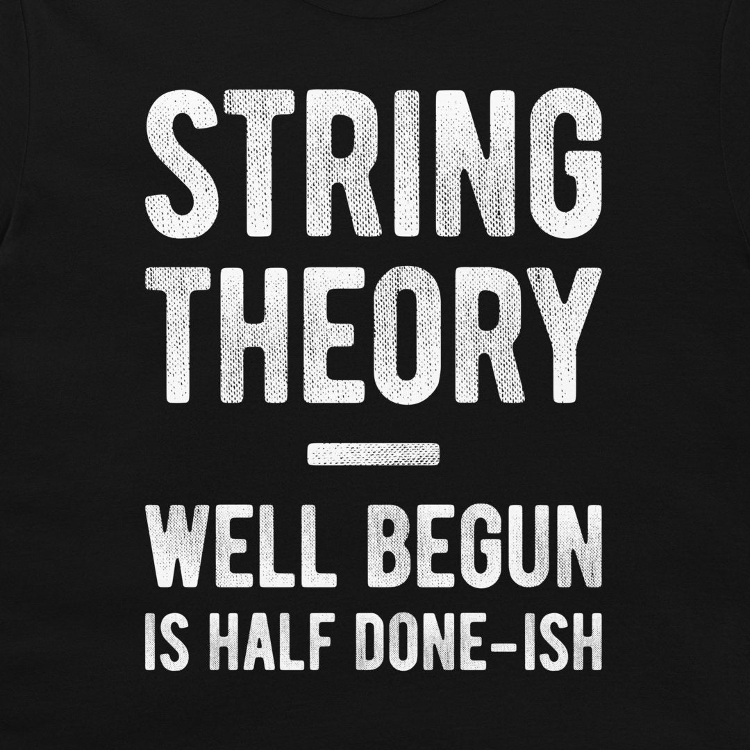 A close-up of a black garment, likely a t-shirt, featuring a distressed white graphic print that reads 'STRING THEORY WELL BEGUN IS HALF DONE-ISH'.