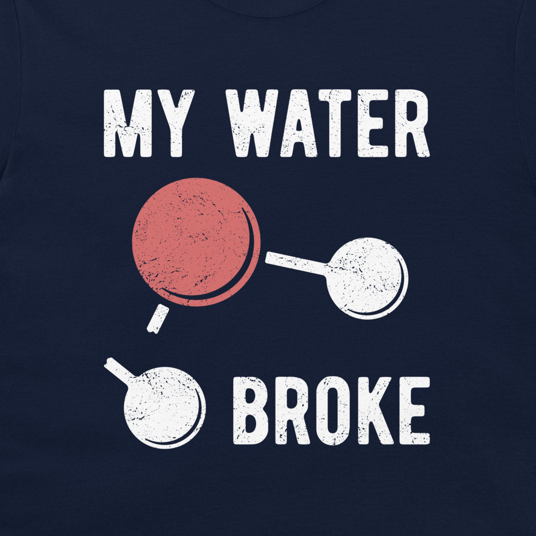 A close-up of a navy blue t-shirt featuring a distressed graphic print that reads 'MY WATER BROKE' with a broken water molecule illustration in white and red.