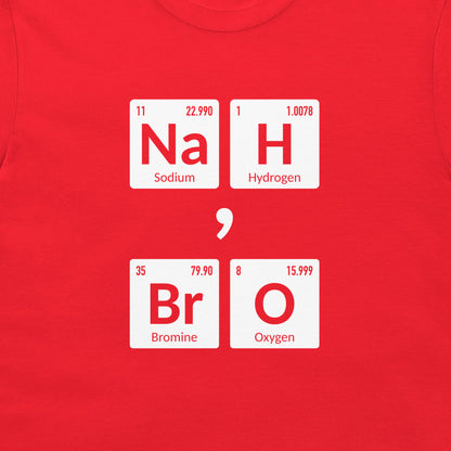 A close-up of a bright red t-shirt, featuring a graphic print of periodic table element tiles that spell out 'Na H Br O' separated by a semicolon.
