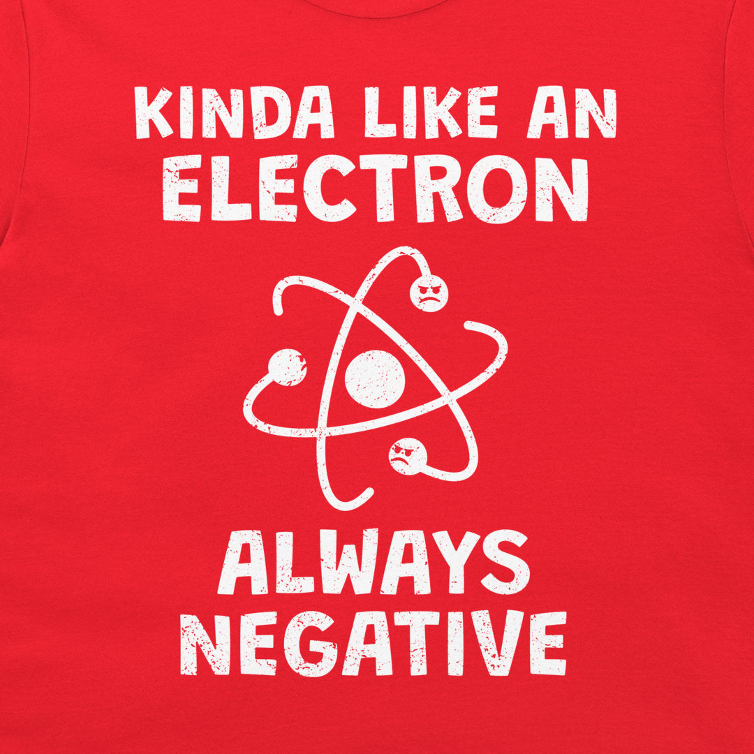 A close-up of a bright red t-shirt, featuring a white distressed graphic print that reads 'KINDA LIKE AN ELECTRON ALWAYS NEGATIVE' with an atom symbol.