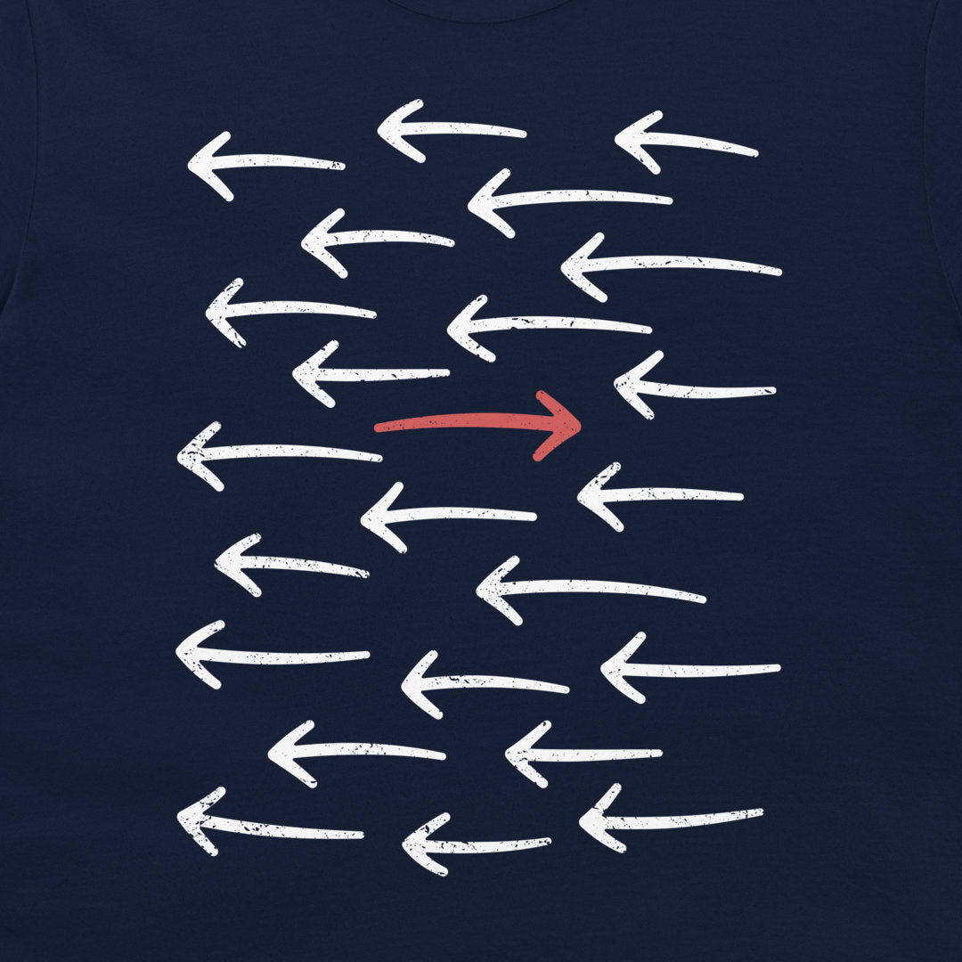 A close-up of a navy blue t-shirt featuring a graphic print of multiple white chalk-style arrows pointing left, with one central arrow pointing right in red.