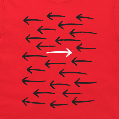 A close-up of a red t-shirt, featuring a graphic print of multiple black hand-drawn arrows pointing left, with one prominent white arrow pointing right in the center.