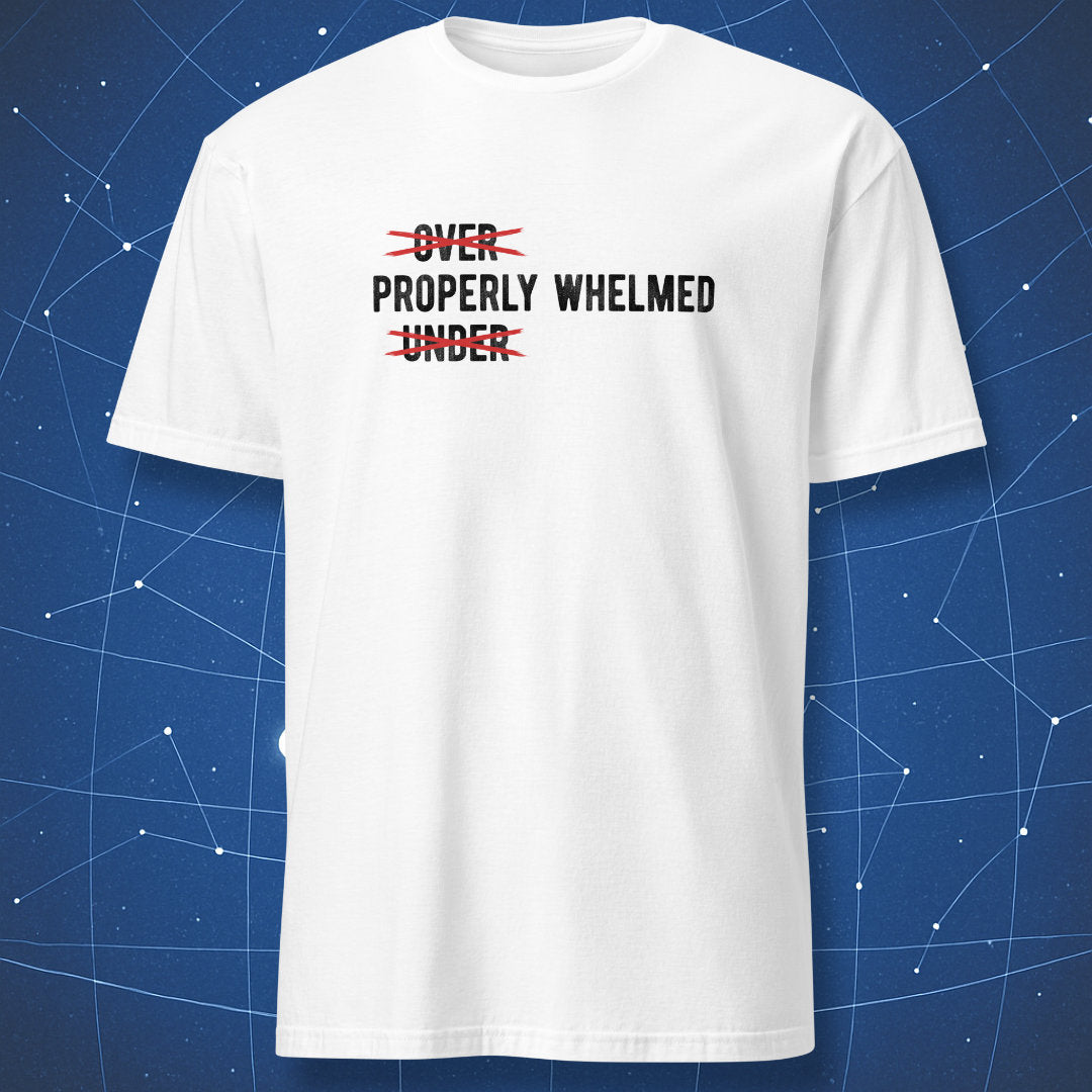 A white short-sleeve crewneck t-shirt with a graphic print on the chest reading 'OVER PROPERLY WHELMED UNDER' crossed out in red scribbles, displayed against a blue starry space background.