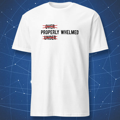A white short-sleeve crewneck t-shirt with a graphic print on the chest reading 'OVER PROPERLY WHELMED UNDER' crossed out in red scribbles, displayed against a blue starry space background.