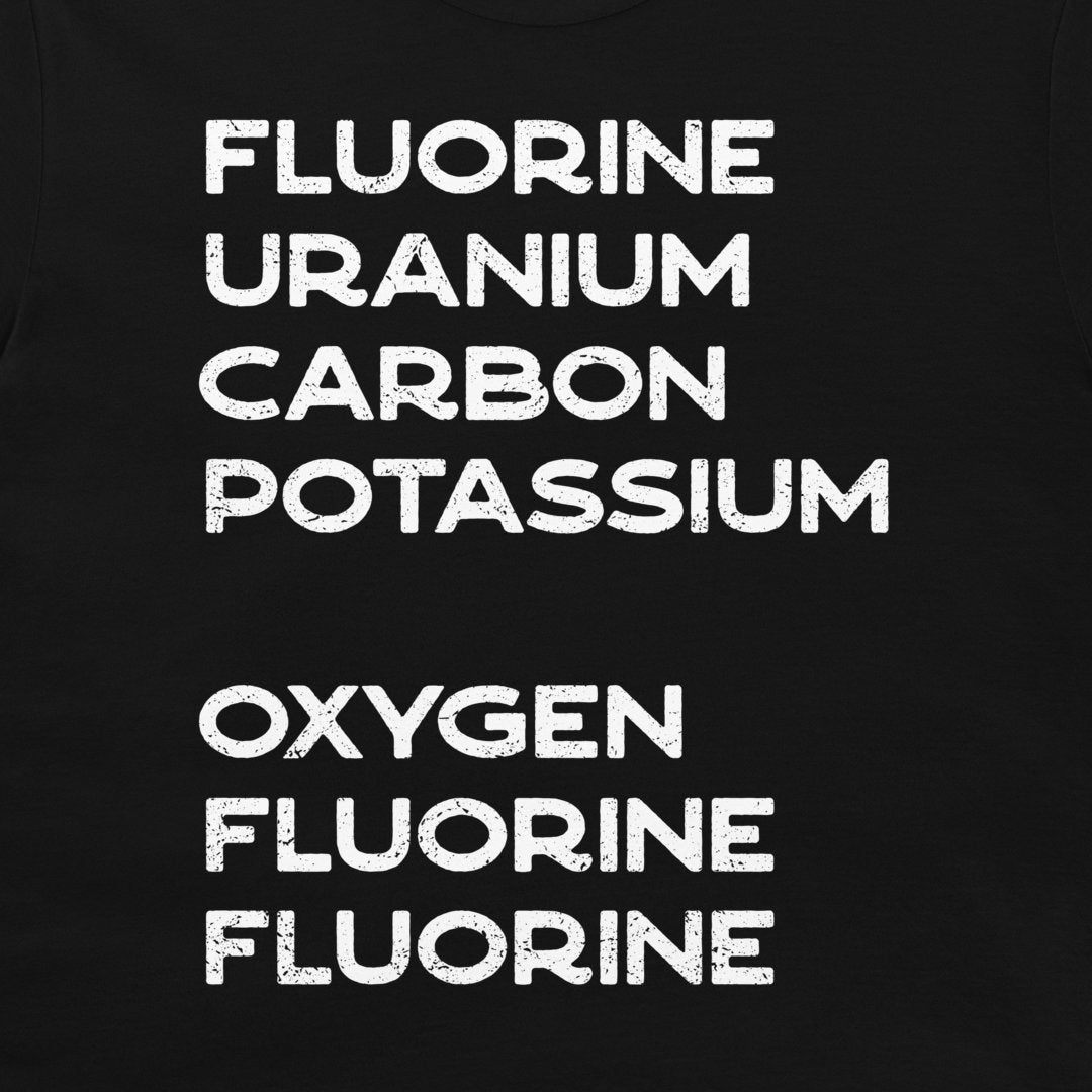 Close-up of white element names forming a hidden chemistry message on a black T-shirt