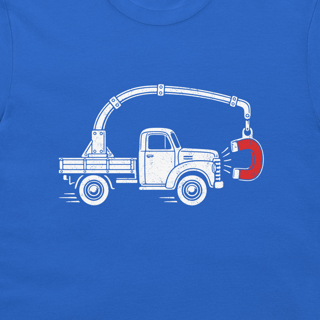 Close-up of the perpetual motion truck and red magnet graphic on a royal blue T-shirt
