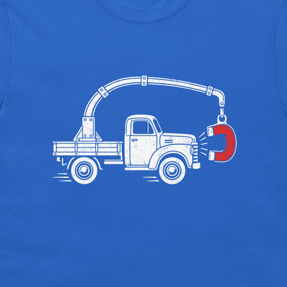 Close-up of the perpetual motion truck and red magnet graphic on a royal blue T-shirt