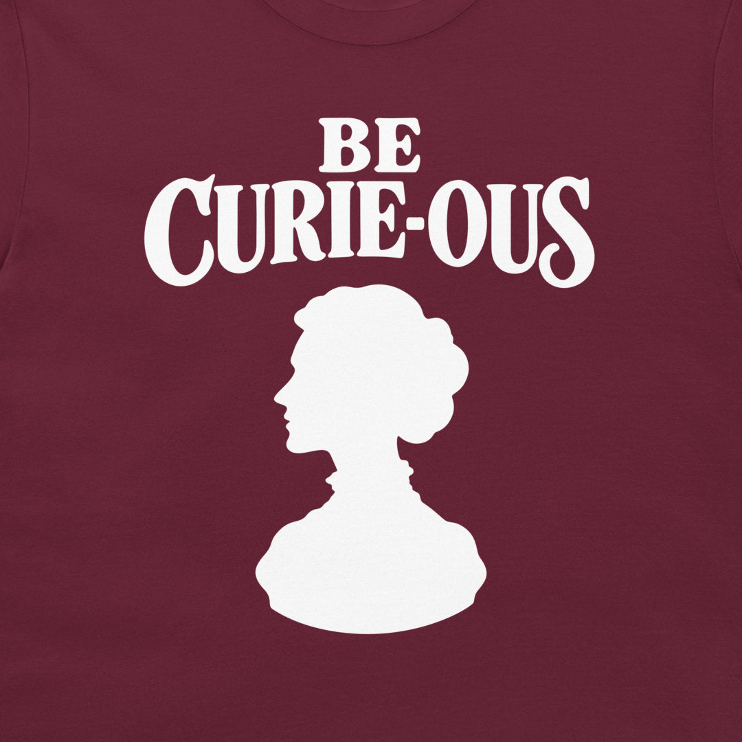 Close-up of the white Be Curie-ous design on a maroon T-shirt.
