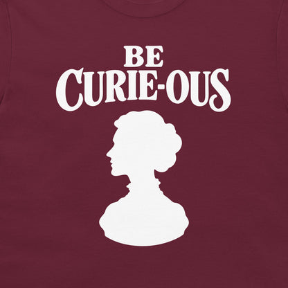Close-up of the white Be Curie-ous design on a maroon T-shirt.