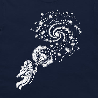 Close-up of dandelion seeds swirling into a galaxy above an astronaut on a navy T-shirt.