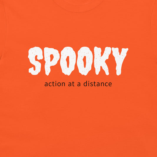 Close-up of white SPOOKY lettering and black action at a distance text on an orange T-shirt.