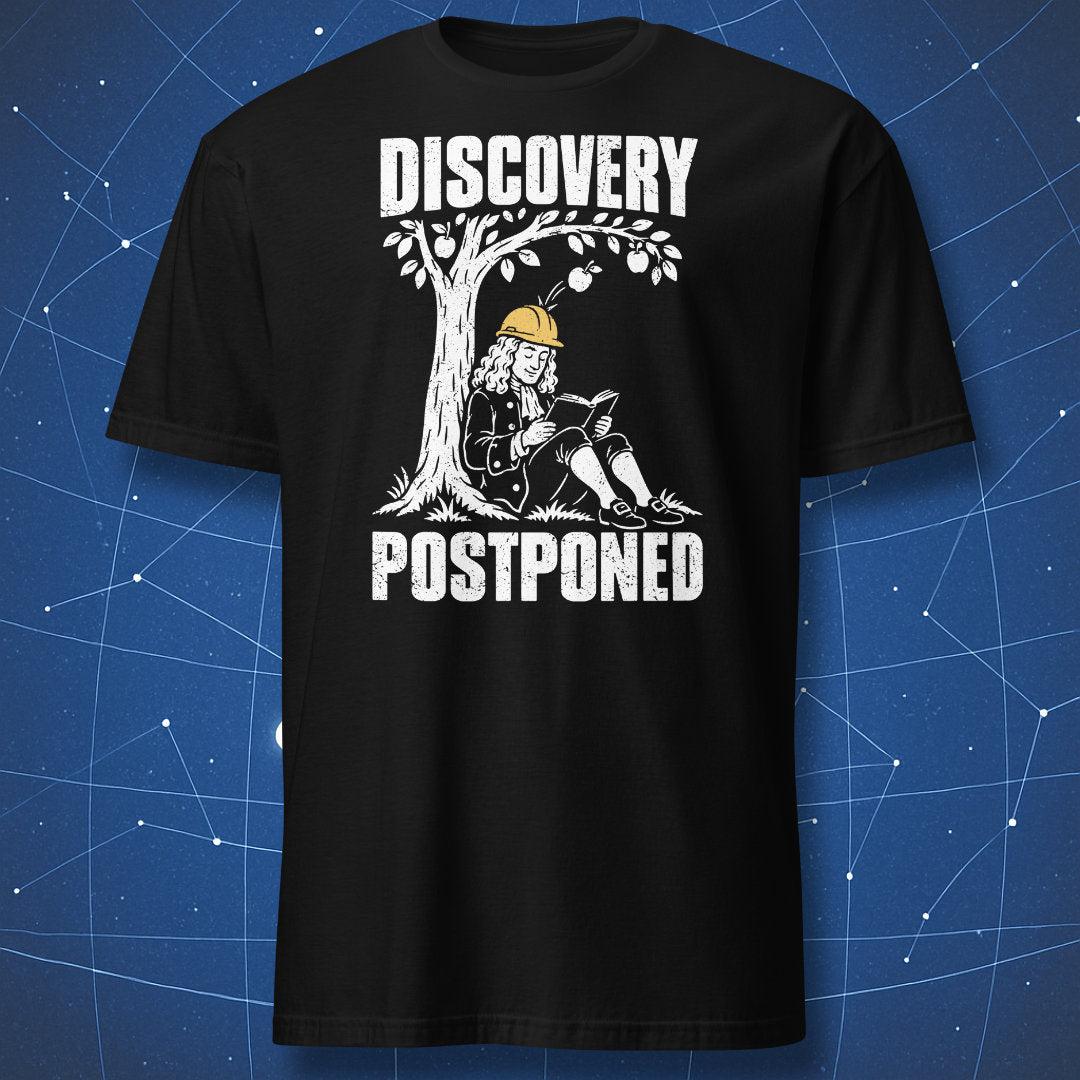 Black Discovery Postponed T-shirt with a white cartoon of Isaac Newton reading under an apple tree in a yellow hard hat.