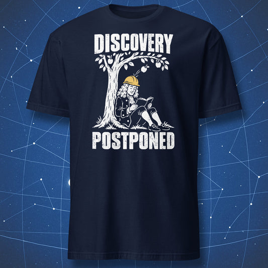 Navy Discovery Postponed T-shirt featuring Isaac Newton in a yellow safety helmet beneath a white apple tree.