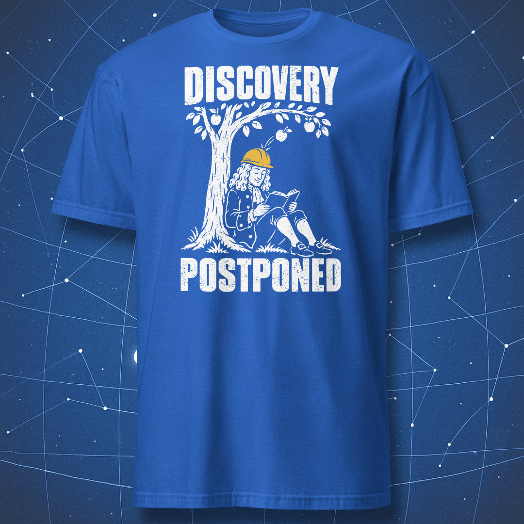 Royal blue Discovery Postponed T-shirt showing Isaac Newton reading beneath an apple tree while wearing a yellow hard hat.