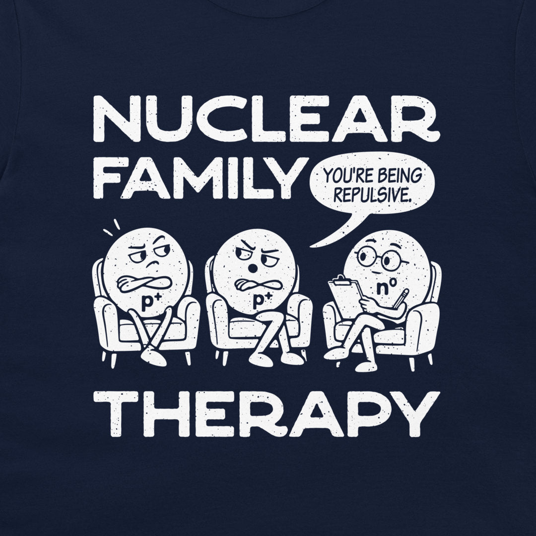 Detail of the two p⁺ protons and n⁰ neutron therapist beneath Nuclear Family Therapy lettering on navy fabric.