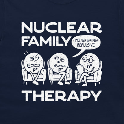 Detail of the two p⁺ protons and n⁰ neutron therapist beneath Nuclear Family Therapy lettering on navy fabric.
