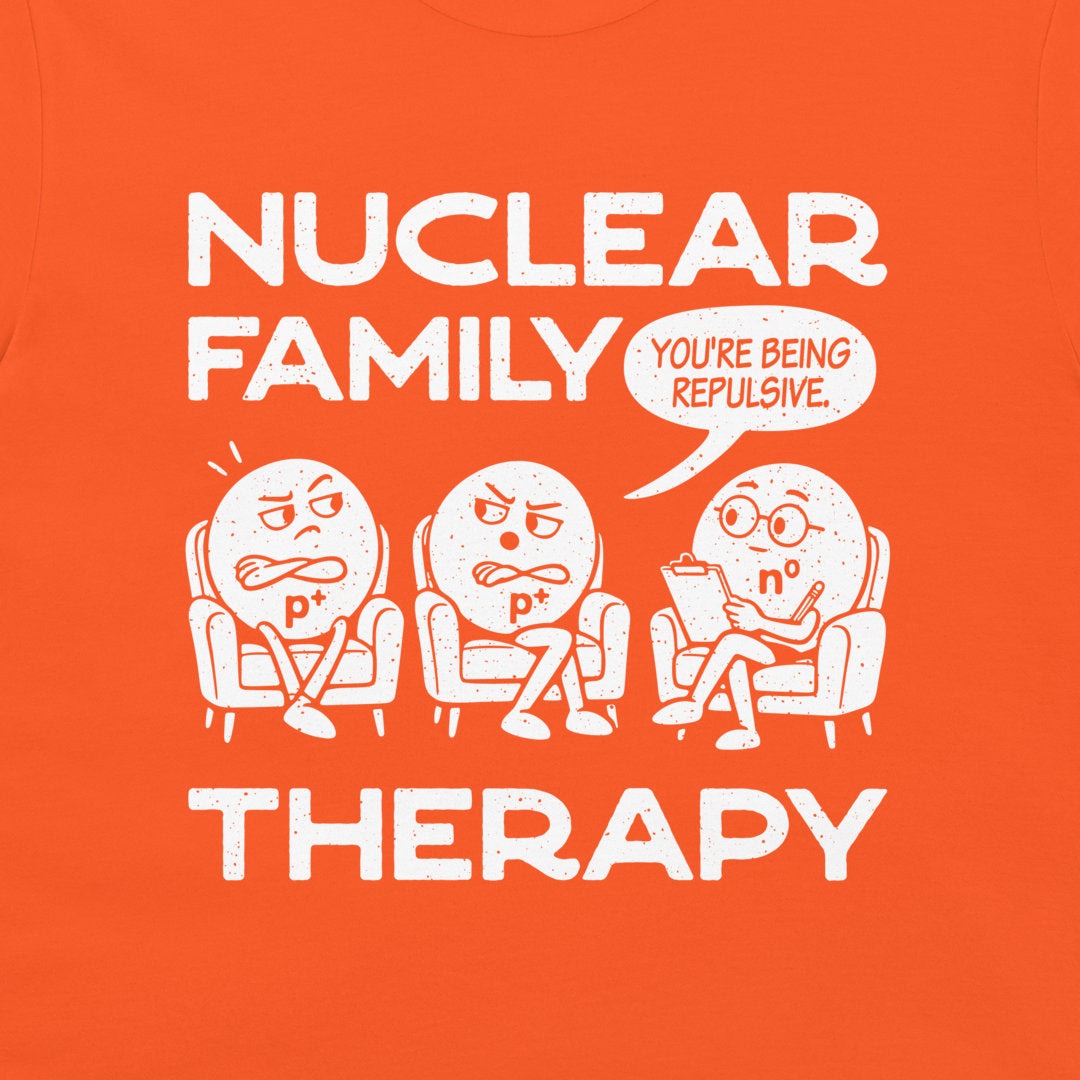 Detail of distressed white Nuclear Family Therapy lettering, proton labels, and the neutron holding a clipboard on orange fabric.
