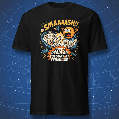 Black T-shirt with comic-style particle collision graphic and text “SMAAASH!! Just a regular Tuesday at Fermilab” — funny physics lab design.