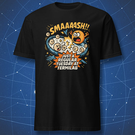 Black T-shirt with comic-style particle collision graphic and text “SMAAASH!! Just a regular Tuesday at Fermilab” — funny physics lab design.