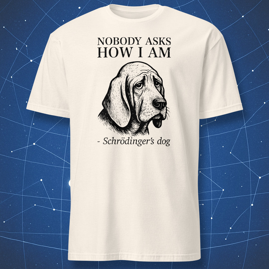 Natural (off-white) T-shirt with a melancholic black dog illustration and the caption “Nobody cares if I’m alive – Schrödinger’s dog” — existential physics joke tee.