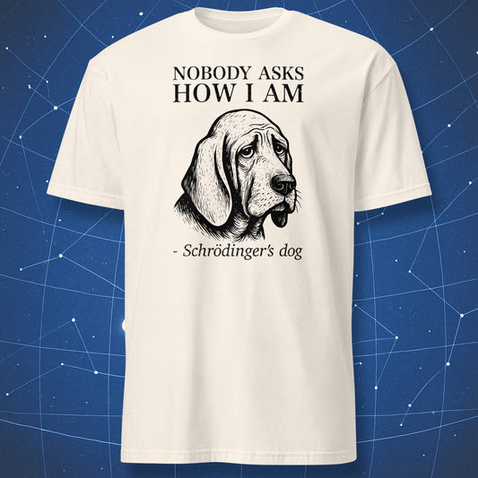 Natural (off-white) T-shirt with a melancholic black dog illustration and the caption “Nobody cares if I’m alive – Schrödinger’s dog” — existential physics joke tee.