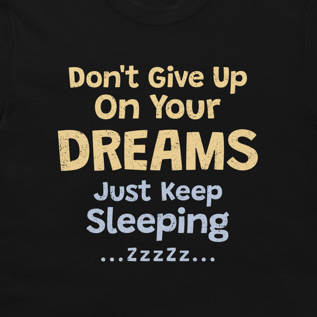 Close-up of the funny “Don't Give Up On Your Dreams – Just Keep Sleeping” design on a black T-shirt.