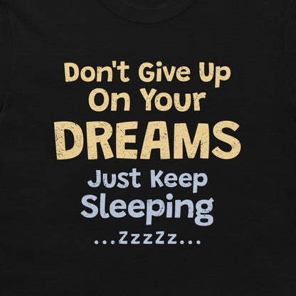 Close-up of the funny “Don't Give Up On Your Dreams – Just Keep Sleeping” design on a black T-shirt.